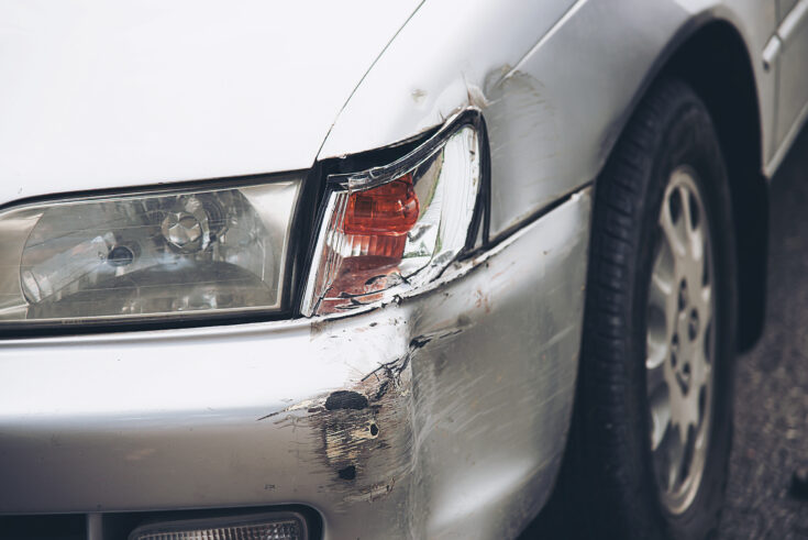 Damaged car bumper and headlight after a collision